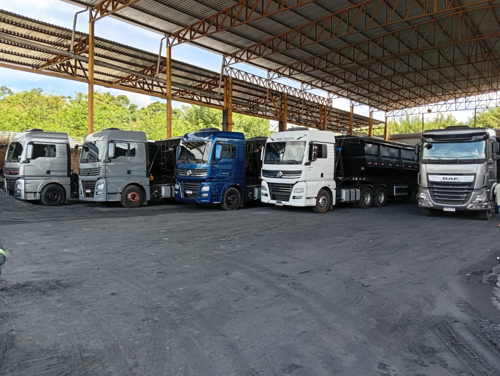 Frota de caminhões da PHR Transportes em pátio coberto